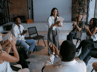 A diverse group of professionals engaged in an animated discussion, with a central figure actively listening with an engaged expression.